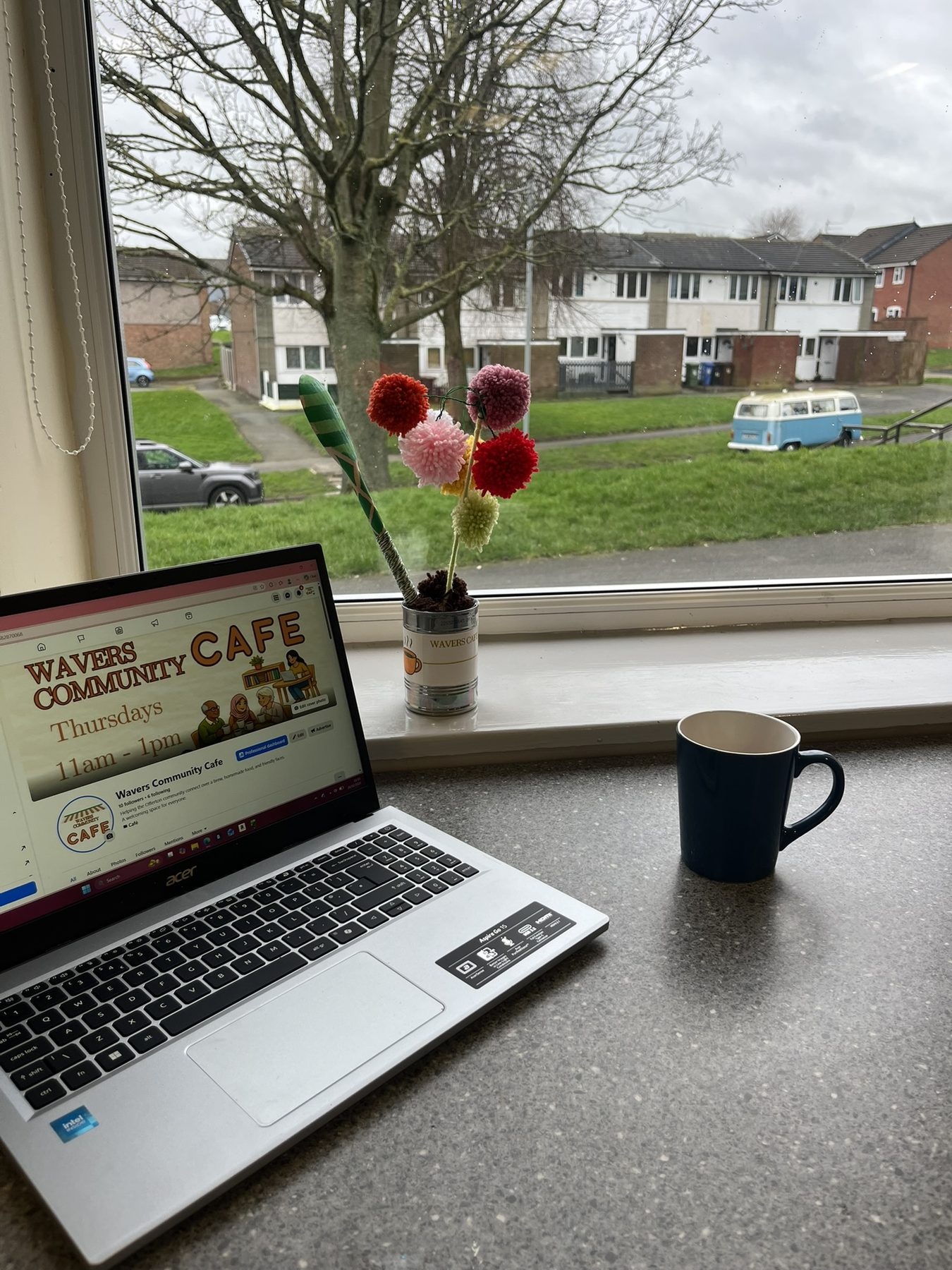 Wavers Community Café Facebook page beside a cup